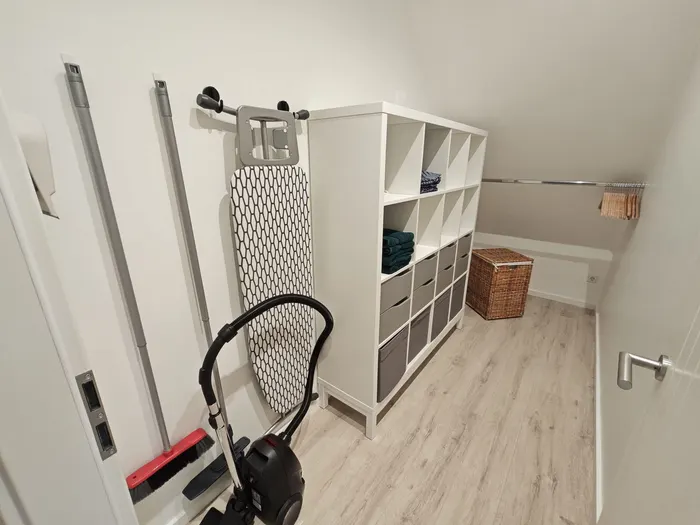 Ankleideraum mit Regal, Bügelbrett und Staubsauger im Ferienhaus Am Pannofen