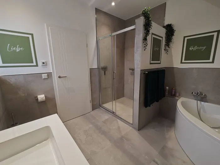 Badezimmer mit ebenerdiger Dusche und Badewanne im Ferienhaus Am Pannofen
