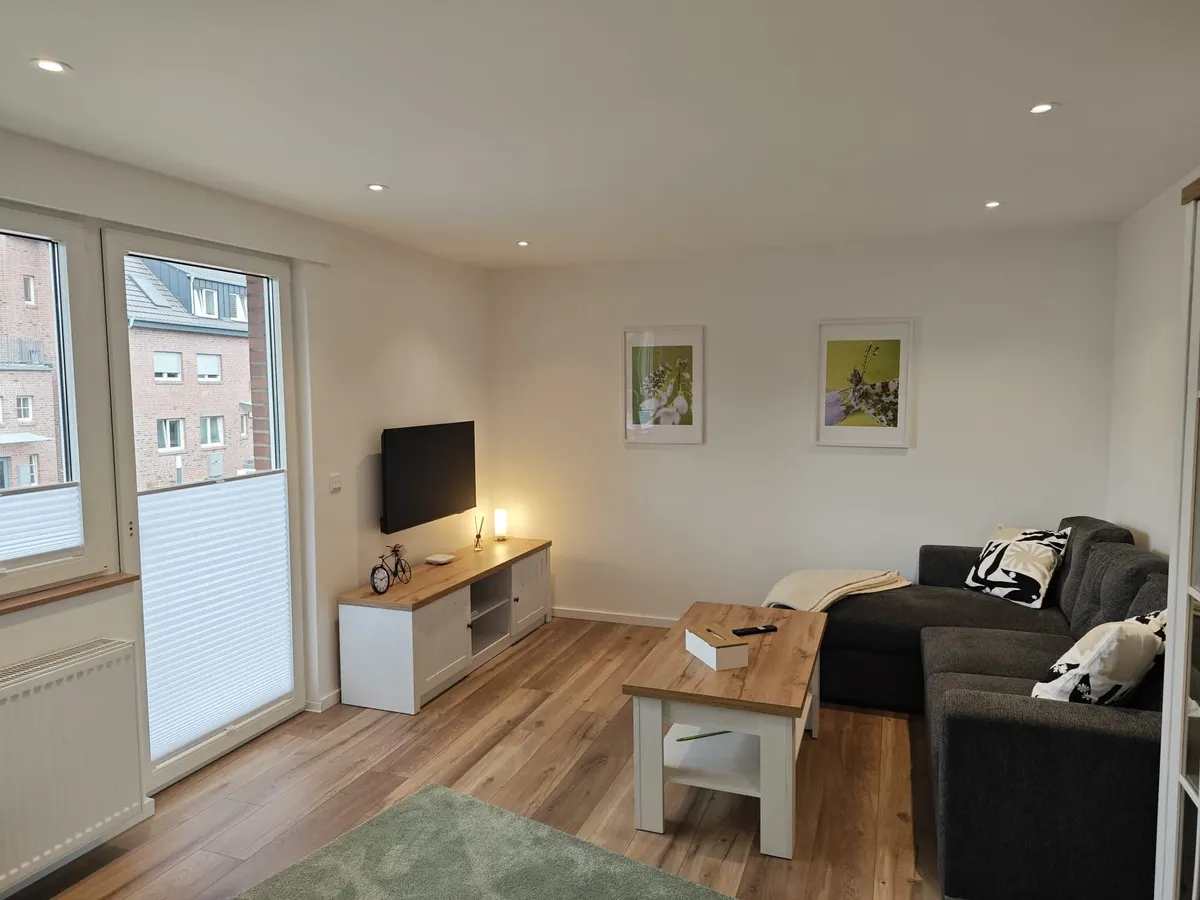 Wohnzimmer mit Sofa, Fernseher und Couchtisch in der Ferienwohnung Friedrich-Spee Obergeschoss
