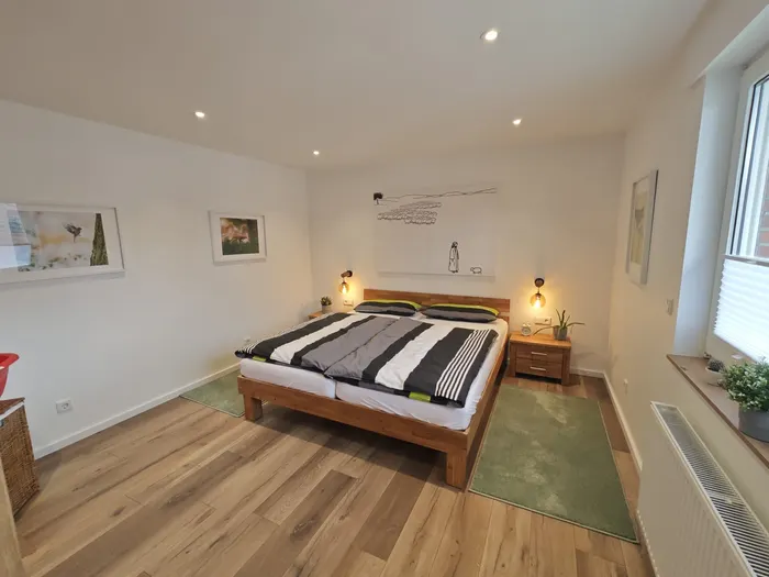 Schlafzimmer mit Doppelbett und Nachttischleuchten in der Ferienwohnung Friedrich-Spee Obergeschoss
