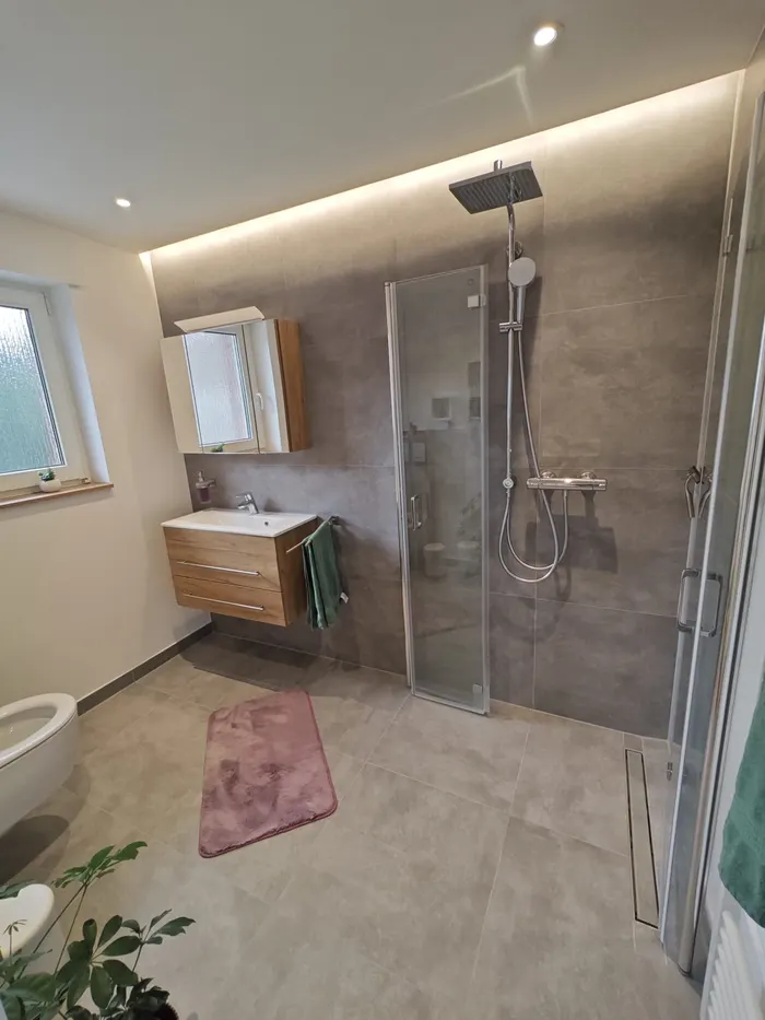 Badezimmer mit Dusche, Waschtisch und Handtuchheizkörper in der Ferienwohnung Friedrich-Spee Obergeschoss