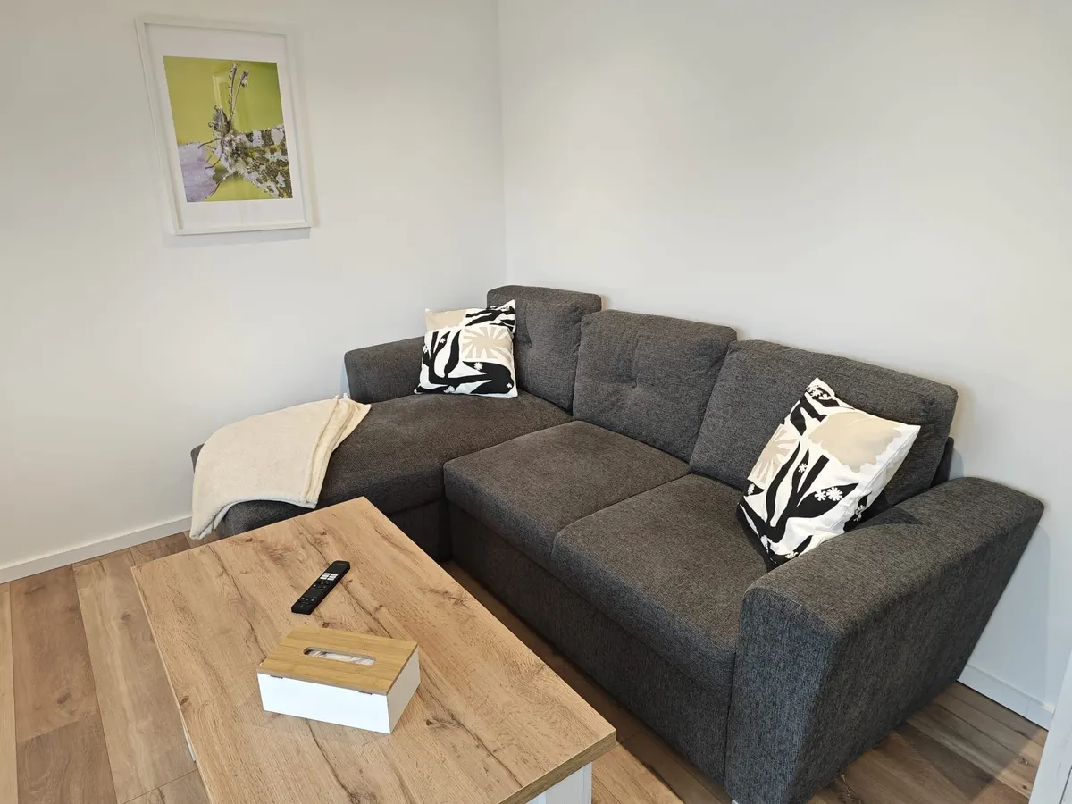 Graues Ecksofa mit hölzernem Couchtisch in der Ferienwohnung Friedrich-Spee Obergeschoss